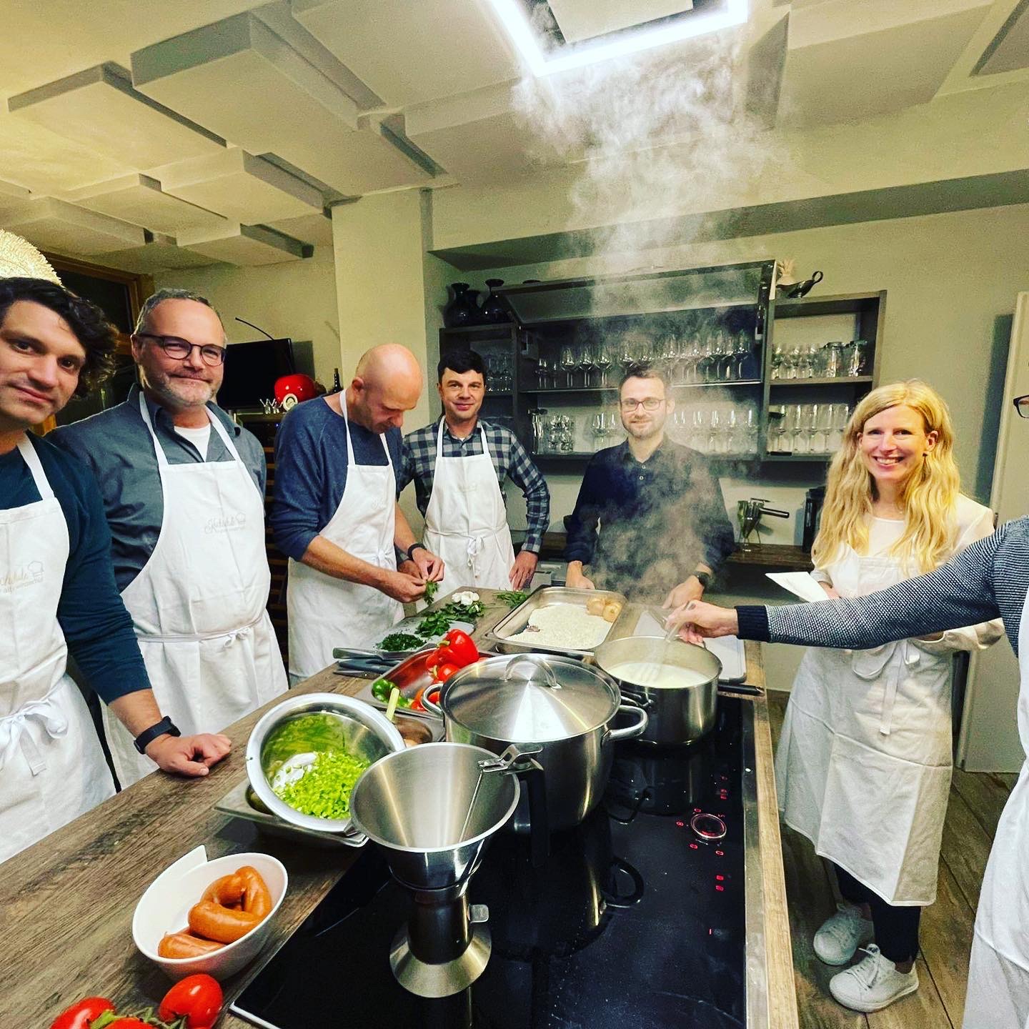 Gruppe beim gemeinsamen Kochen in der Kochschule des Alten Winzerhofs